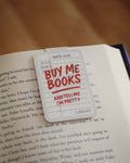 'Buy Me Books And Tell Me I'm Pretty' magnetic bookmark clipped on an open book.