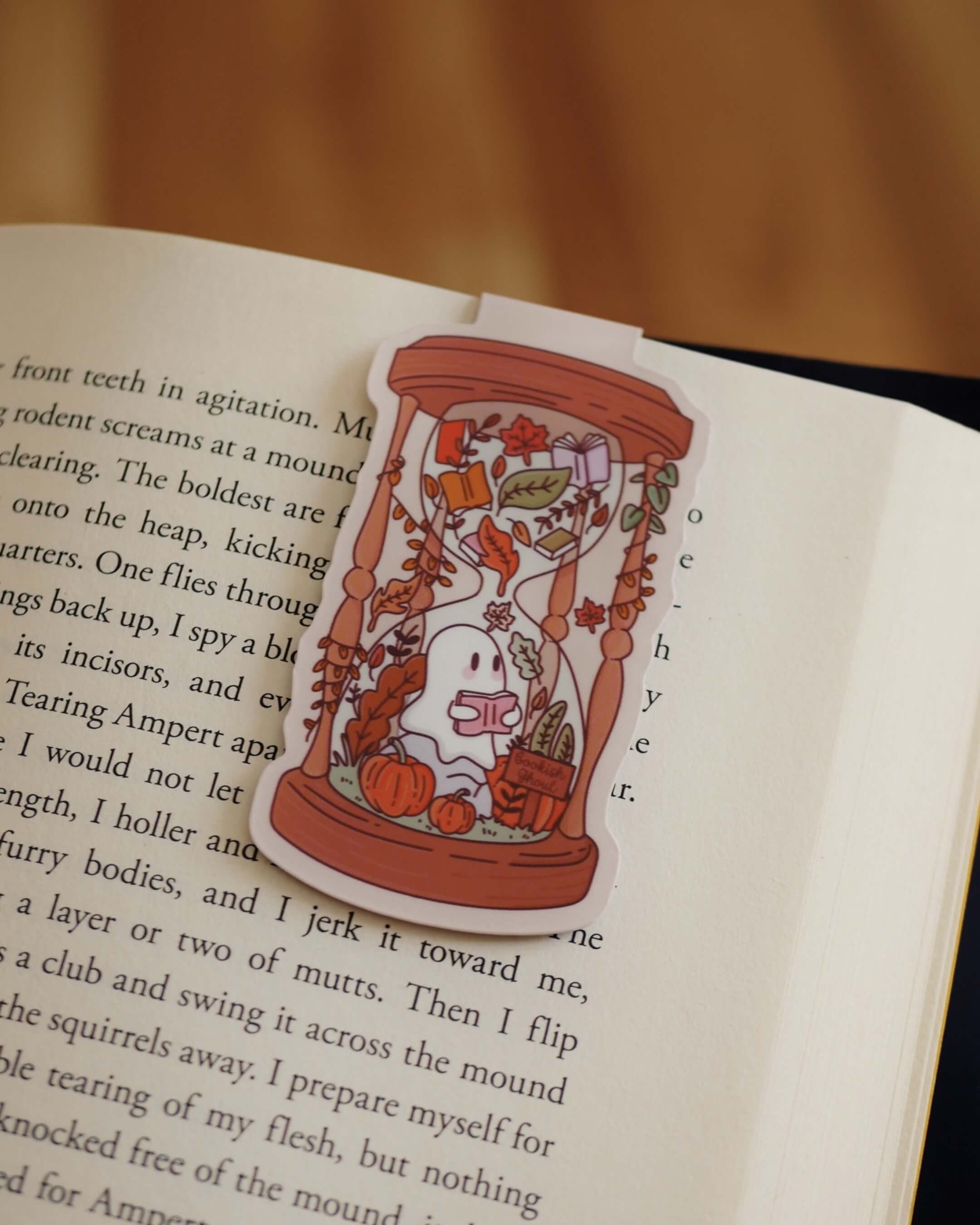 Magnetic bookmark of a ghost in an hourglass design on an open book.