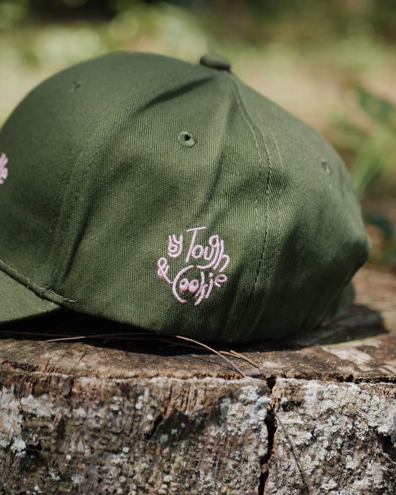 Green cap with a logo on a wooden surface outdoors