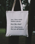 Tote bag with humorous text about talents held by a person outdoors