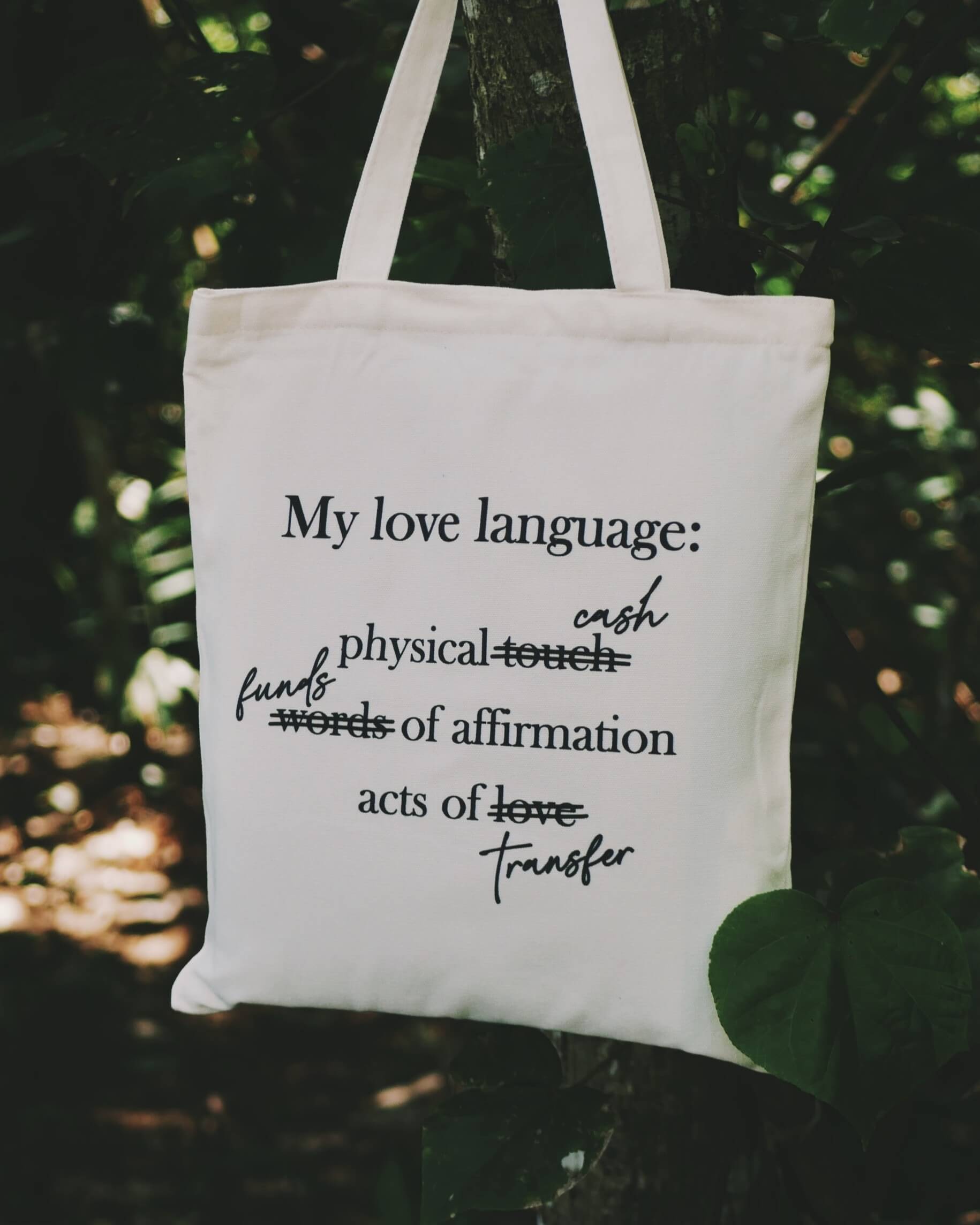 Tote bag with text about love languages against a natural background