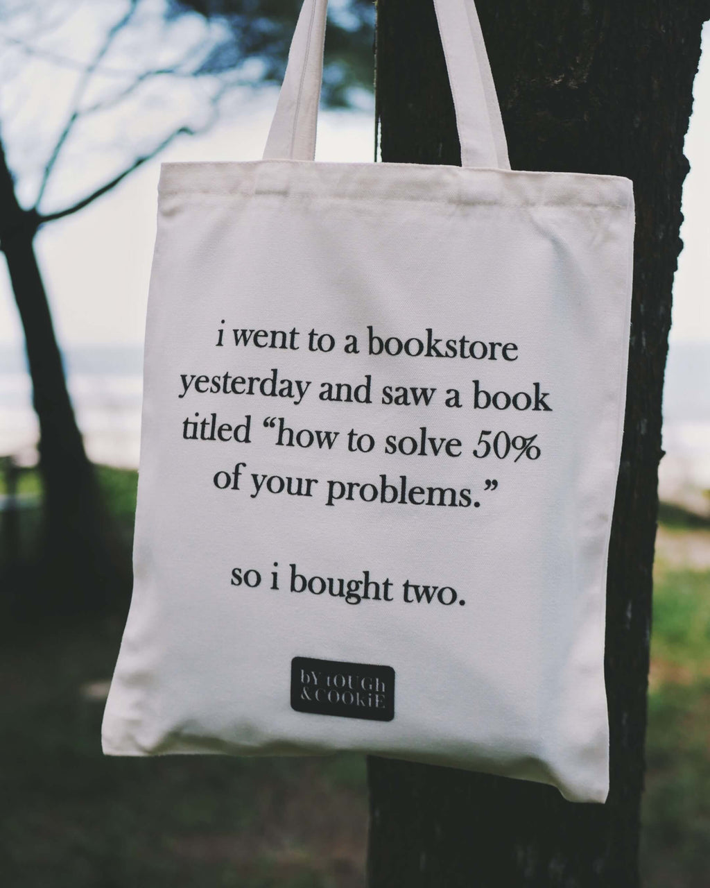 Tote bag with humorous text about a bookstore and books titled 'how to solve 50% of your problems'.