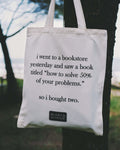 Tote bag with humorous text about a bookstore and books titled 'how to solve 50% of your problems'.