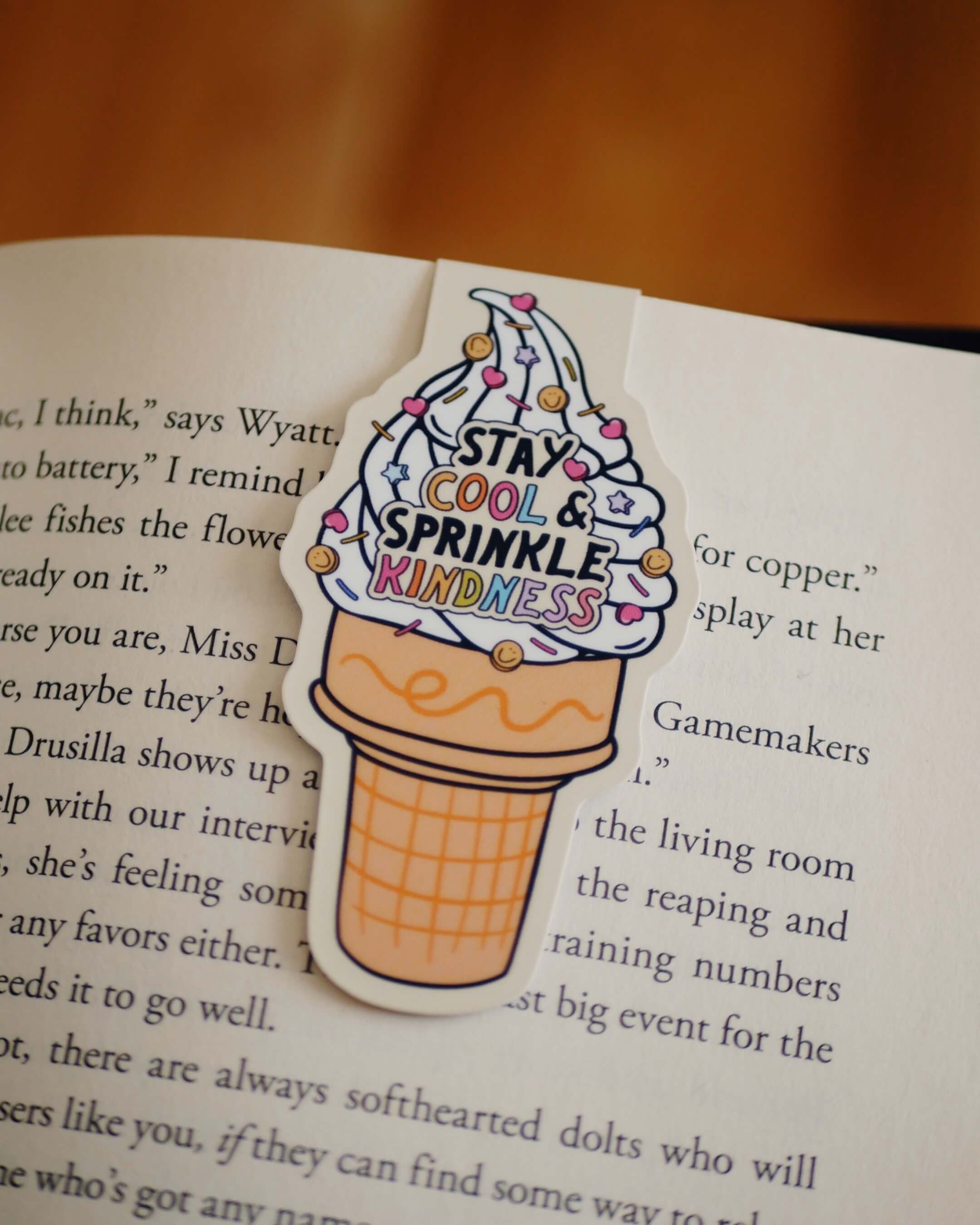 Ice cream cone-shaped magnetic bookmark with 'Stay Cool & Sprinkle Kindness' clipped on a page.